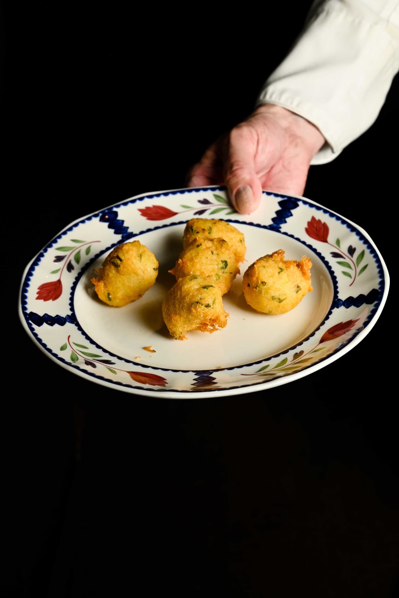 Buñuelos de bacalao servidos en plato de cerámica tradicional